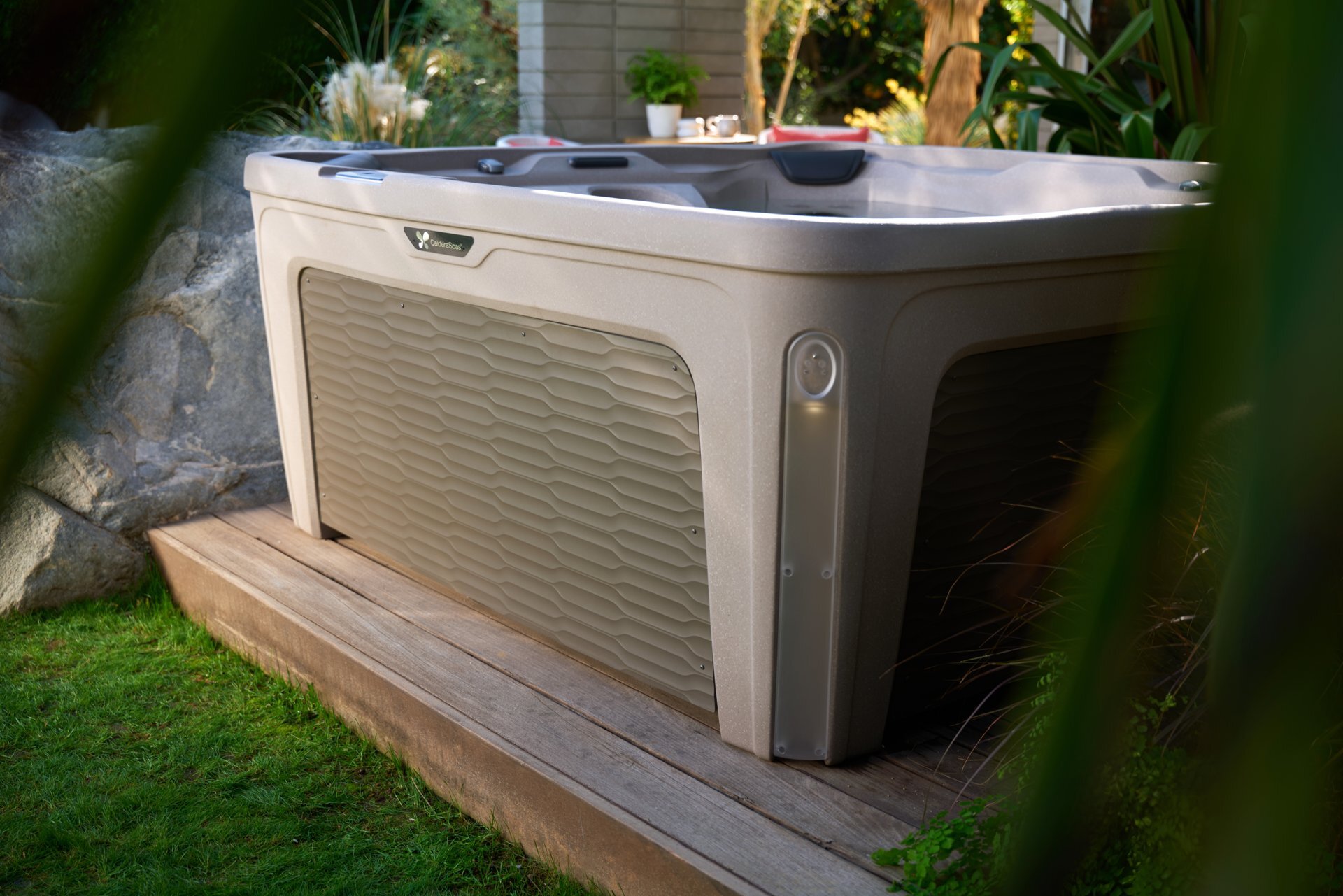 Caldera Fantasy Bloom spa tucked into a leafy backyard corner