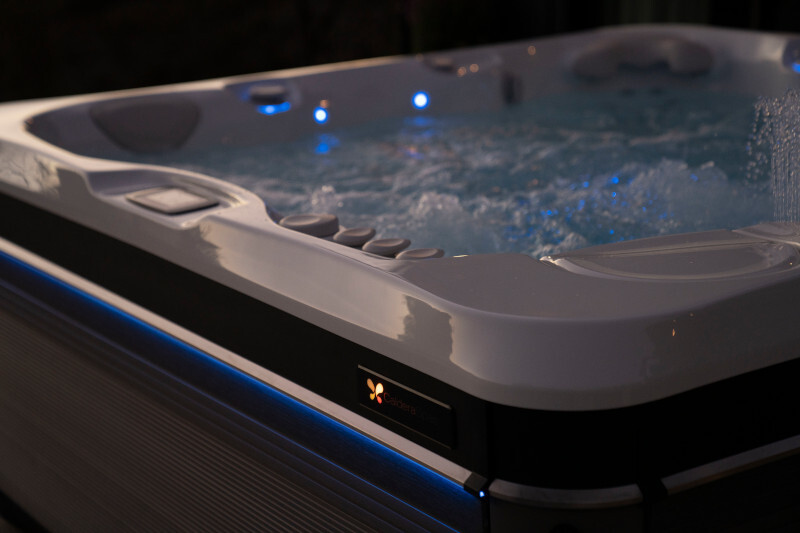 A Caldera Utopia Geneva spa lit at dusk with the waterfall running