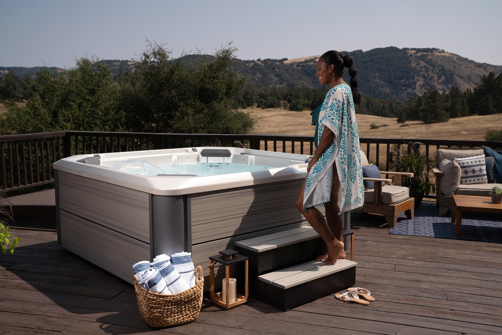 A woman beside a Hot Spring Hot Spot Rhythm spa