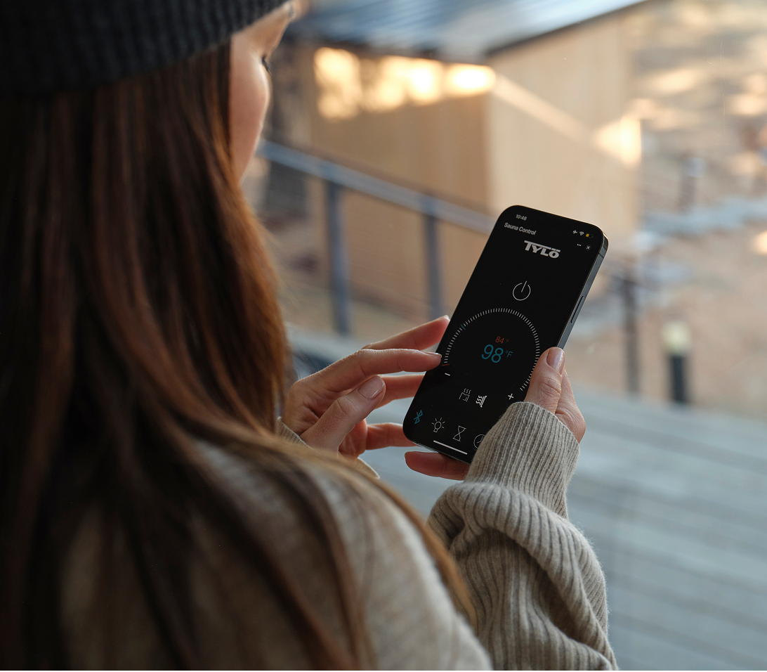 Woman starting her Tylo sauna from the Sauna App on her phone