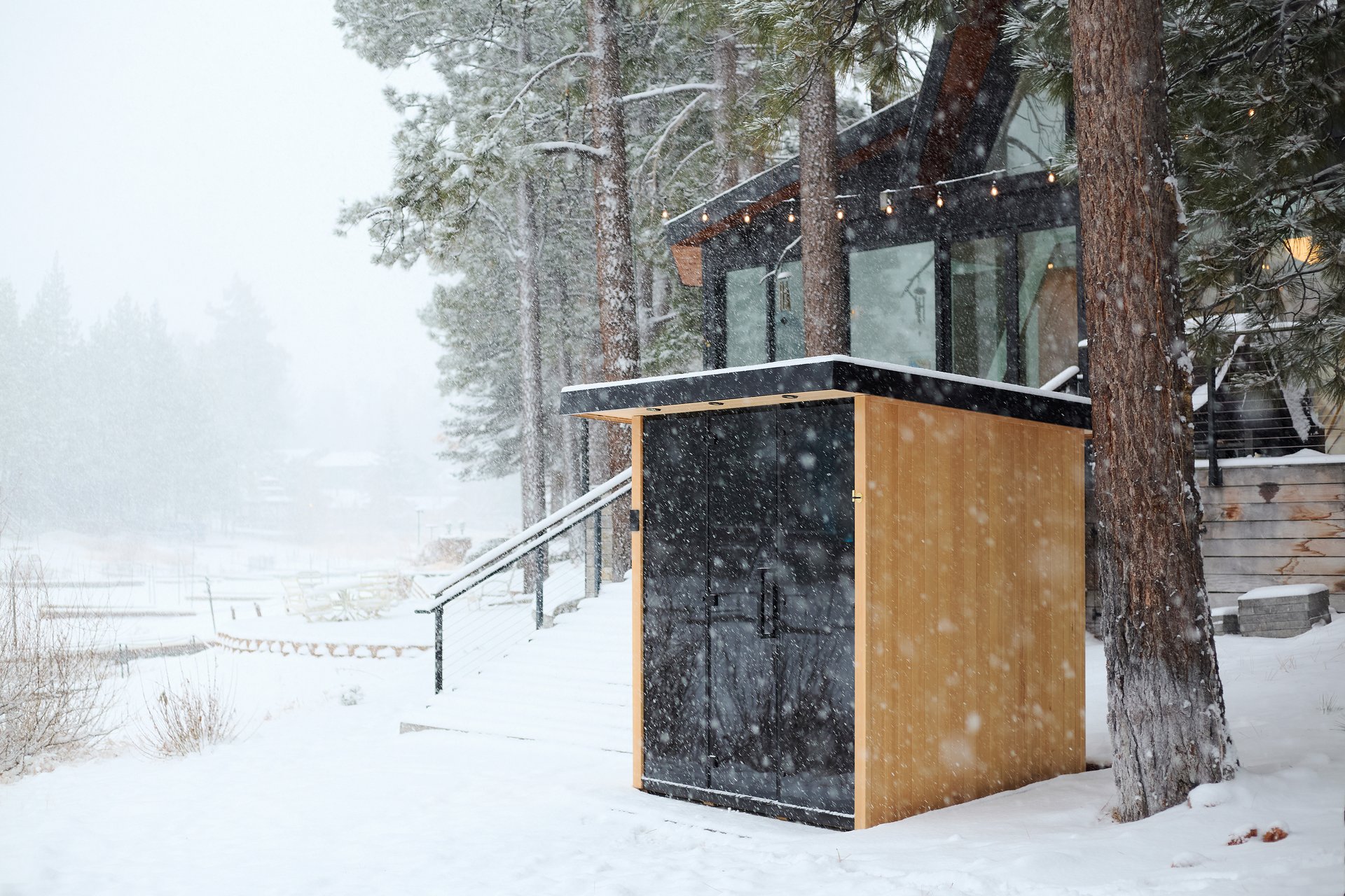 A Tylo Lulea outdoor sauna in a snowy backyard